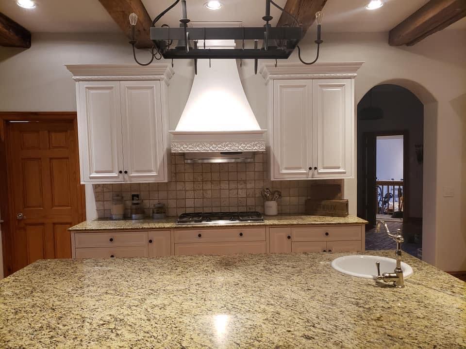 Refinished white kitchen cabinets under wood beams in Springfield, Missouri