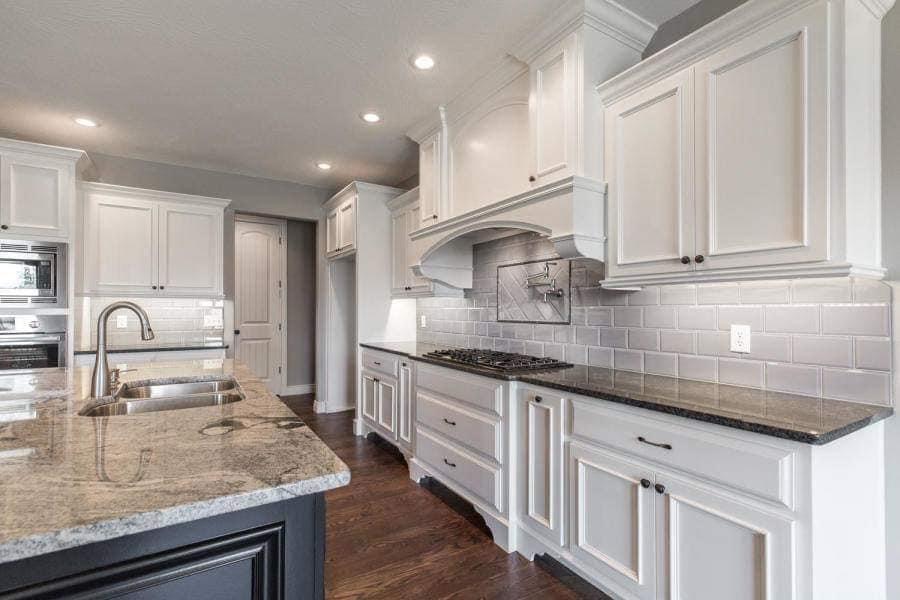 Sprayed white kitchen cabinets with custom hood surround in Springfield, Missouri