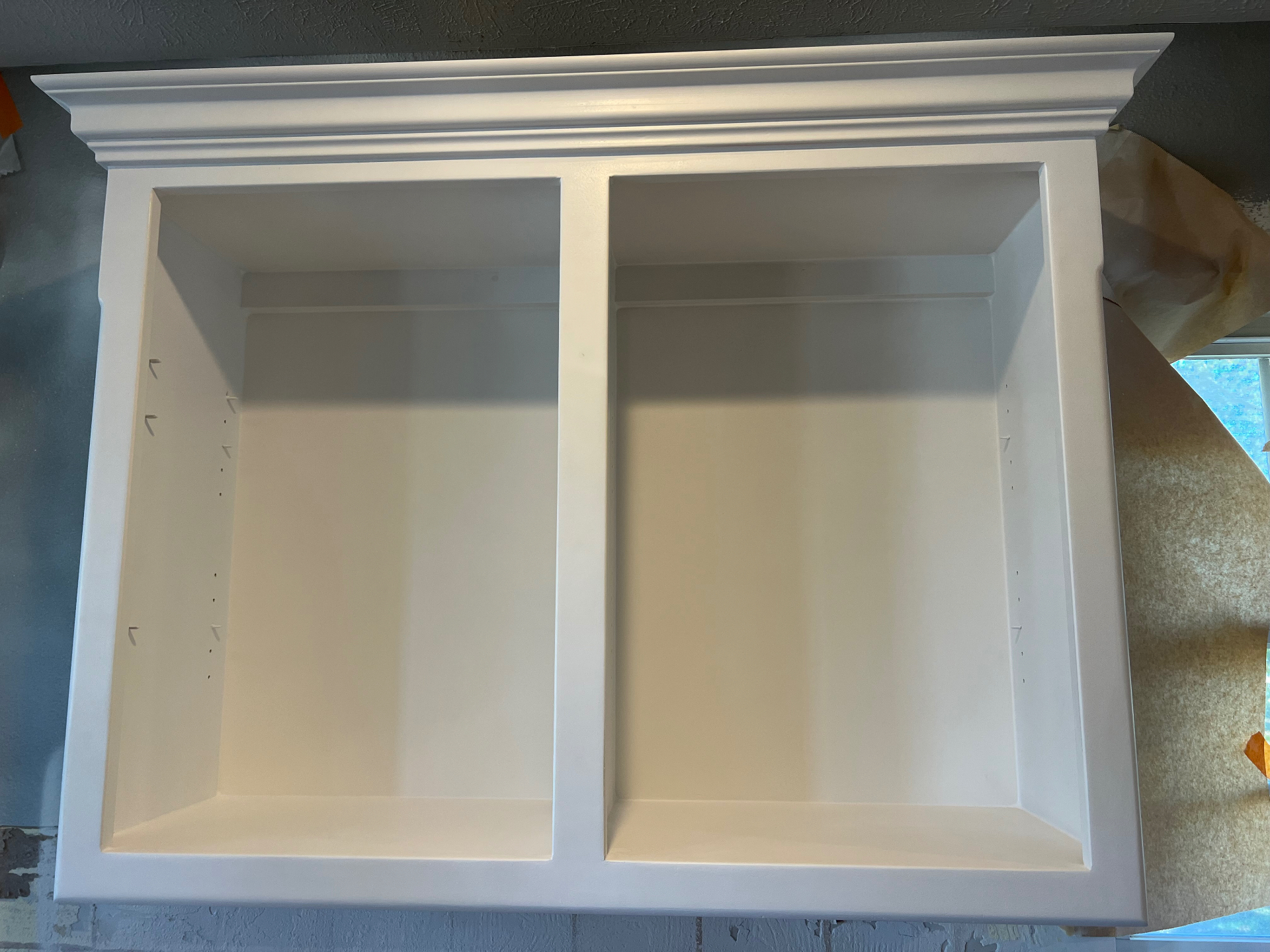 Cabinet box and crown molding sprayed white during a kitchen refinishing job