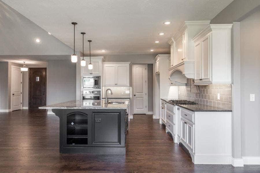 White cabinets with a black painted kitchen island in Ozark, Missouri